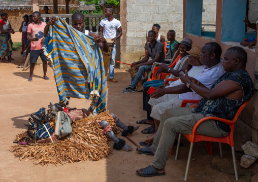 We Guere sacred mask resting in front of the village leaders during a ceremony, Guémon, Bangolo, Ivory Coast