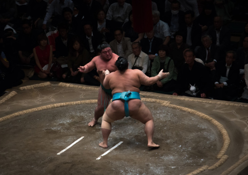 Two sumo wrestlers fighting at the ryogoku kokugikan arena, Kanto region, Tokyo, Japan