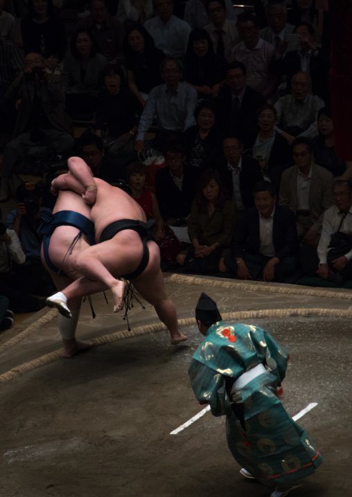Two sumo wrestlers fighting at the ryogoku kokugikan arena, Kanto region, Tokyo, Japan