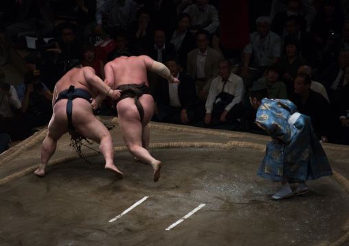 Two sumo wrestlers fighting at the ryogoku kokugikan arena, Kanto region, Tokyo, Japan