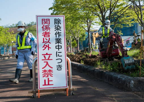 Decontamination work no entry sign in front of workers who remove top soil contaminated by nuclear radiations after the daiichi nuclear power plant explosion, Fukushima prefecture, Iitate, Ja