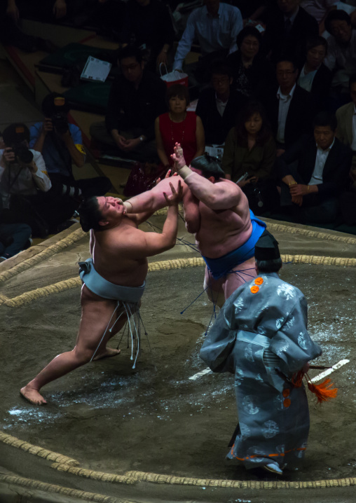 Two sumo wrestlers fighting at the ryogoku kokugikan arena, Kanto region, Tokyo, Japan