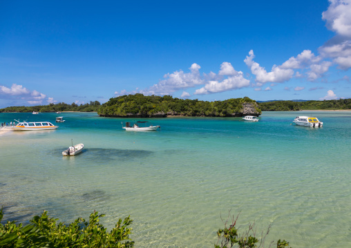 Glass bottom boats in the tropical lagoon beach with clear blue water and white sand in Kabira bay, Yaeyama Islands, Ishigaki, Japan