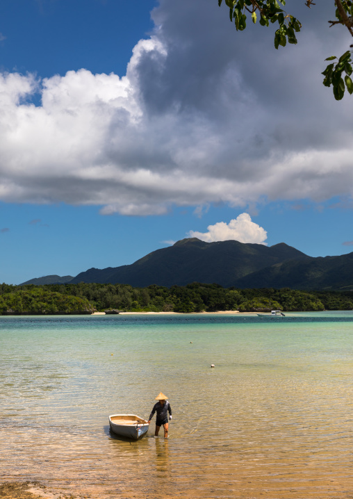 Japanese fisherman in tropical lagoon with clear blue water in Kabira bay, Yaeyama Islands, Ishigaki, Japan