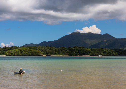 Japanese fisherman in tropical lagoon with clear blue water in Kabira bay, Yaeyama Islands, Ishigaki, Japan