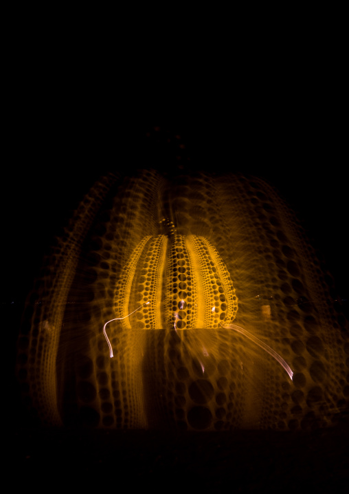 Yellow pumpkin by Yayoi Kusama on pier at night with a zoom effect, Seto Inland Sea, Naoshima, Japan