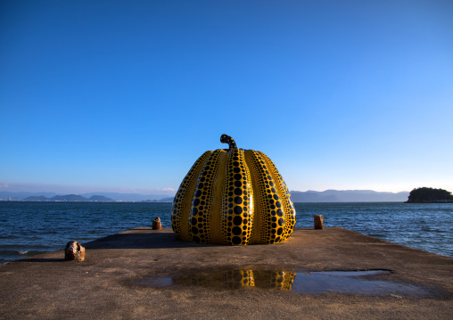 Yellow pumpkin by Yayoi Kusama on pier at sea, Seto Inland Sea, Naoshima, Japan