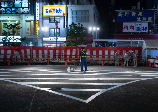 Police man in the street at night, Kanto region, Tokyo, Japan