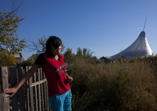 Woman Looking At Khan Shatyr Giant Tent From Her Garden In The Suburbs Of Astana, Kazakhstan