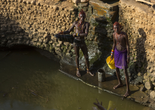 Rendille tribe men taking water in a singing well for their camels, Marsabit district, Ngurunit, Kenya