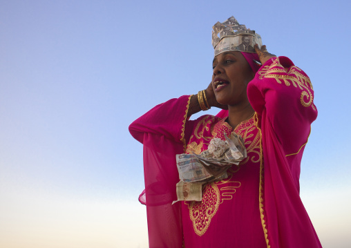 Woman wearing ban knotes hat during Maulid festival, Lamu County, Lamu, Kenya