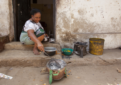 Kenyan woman cooking in the street, Lamu County, Lamu, Kenya