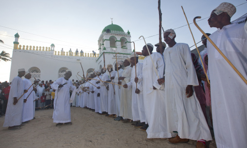 Muslim men singing and dancing with goma sticks during Maulid festival, Lamu county, Lamu, Kenya