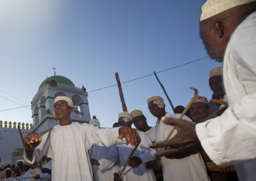 Muslim men singing and dancing with goma sticks during Maulid festival, Lamu County, Lamu, Kenya