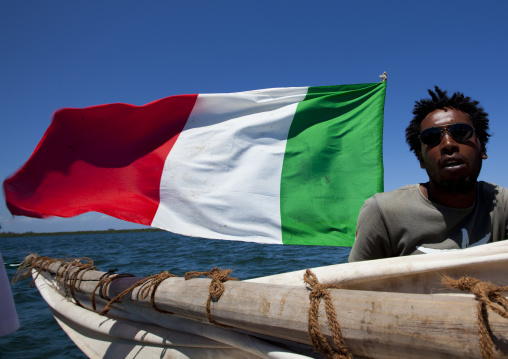 Kenyan man with italian flag on a dhow, Lamu County, Lamu, Kenya