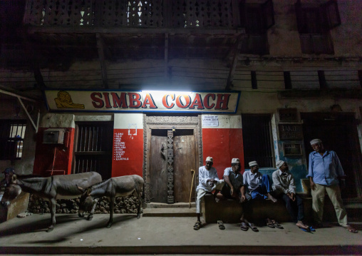 Mulsim men chatting on a bench in the old town, Lamu County, Lamu, Kenya