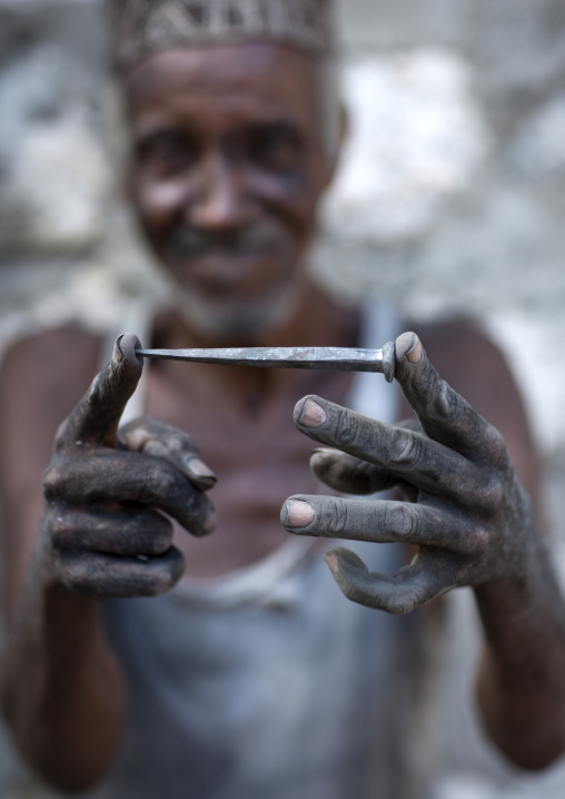 Blacksmith showing a forged nail for the boats, Lamu county, Matondoni, Kenya