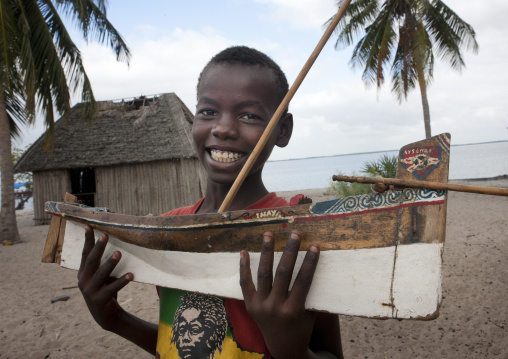 Young boy playing with a dhow boat model, Lamu County, Lamu, Kenya