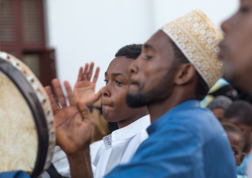 Sunni muslim men playing tambourines during the maulidi festivities in the street, Lamu county, Lamu town, Kenya