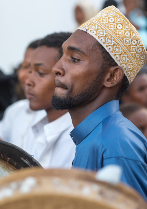 Sunni muslim men playing tambourines during the maulidi festivities in the street, Lamu county, Lamu town, Kenya