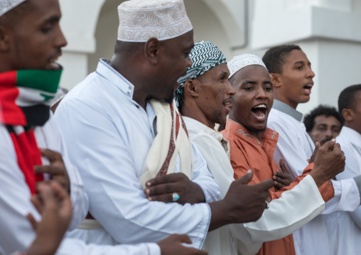 Sunni muslim men dancing during the maulidi festivities in the street, Lamu county, Lamu town, Kenya