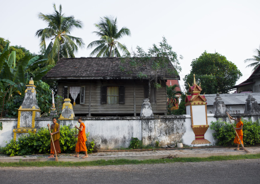 Monks cleaning in front of a monastery, Savannakhet, Laos