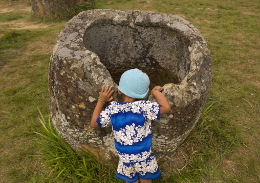 Little girl looking inside a jar, Plain of jars, Phonsavan, Laos