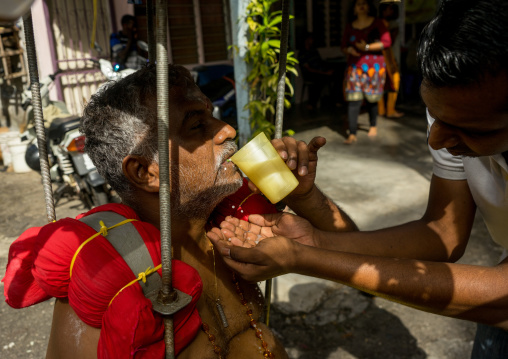 Woman Giving Water To An Hindu Devotee In Annual Thaipusam Religious Festival In Batu Caves, Southeast Asia, Kuala Lumpur, Malaysia
