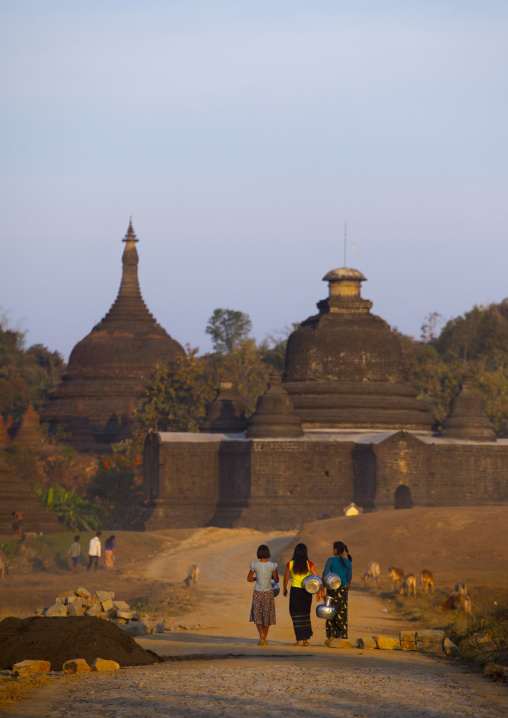 Women Carrying Water In Front Of A Buddhist Temple, Mrauk U, Myanmar