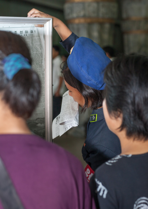 North Korean people reading the offical state newspaper in a subway station, Pyongan Province, Pyongyang, North Korea