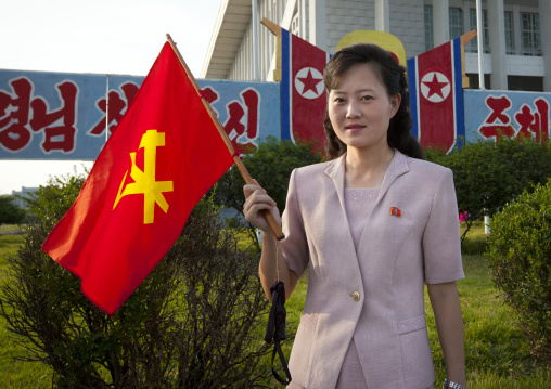 North Korean woman with a workers' Party of North Korea flag during the september 9 parade, Pyongan Province, Pyongyang, North Korea