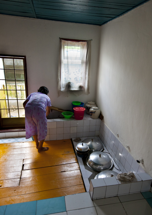 Woman cooking in her kitchen, North Hwanghae Province, Sariwon, North Korea
