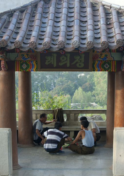 Group of North Korean men eating under a pavillon, North Hwanghae Province, Sariwon, North Korea