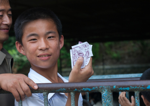 North Korean children waiting with tickets to get on the big wheel at Taesongsan funfair, Pyongan Province, Pyongyang, North Korea