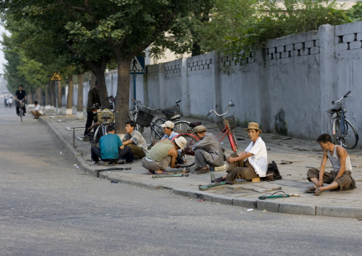 North Korean repairing bicycles in the street, Pyongan Province, Pyongyang, North Korea