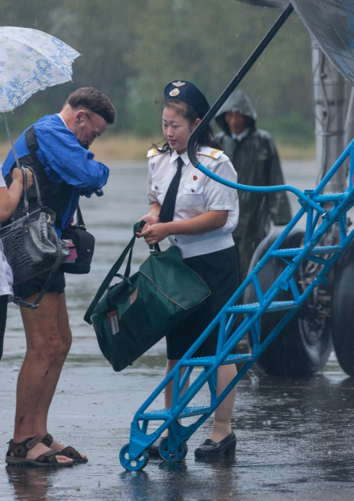 Tourists controled by an airport employee before entering a domestic plane, South Hamgyong Province, Hamhung, North Korea