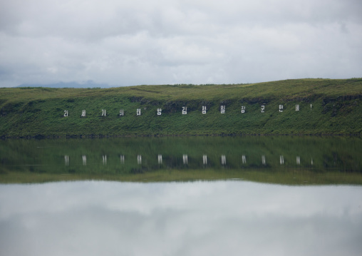Propaganda billboard in front of a lake, North Hamgyong Province, Chilbosan, North Korea