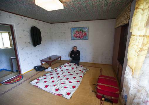 Tourist in a North Korean bedroom in a homestay, North Hamgyong Province, Jung Pyong Ri, North Korea