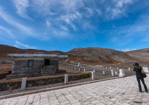 Tourist taking a picture of the entrance road to mount Paektu, Ryanggang Province, Mount Paektu, North Korea