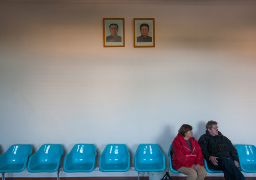 Foreign toursist couple in an airport lounge with the Dear Leaders portaits, Ryanggang Province, Samjiyon, North Korea
