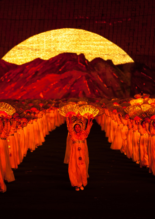 North Korean dancers in front of rising sun over mount Paektu made by children holding up boards during Arirang mass games in may day stadium, Pyongan Province, Pyongyang, North Korea
