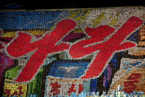 Korean letters made by children pixels holding up colored boards during Arirang mass games in may day stadium, Pyongan Province, Pyongyang, North Korea