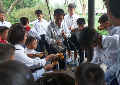 North Korean children drinking from a well at Kim il Sung Mangyongdae native house, Pyongan Province, Pyongyang, North Korea