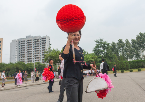 North Korean women with plastic flowers going celebrate the day of the foundation of the republic, Pyongan Province, Pyongyang, North Korea