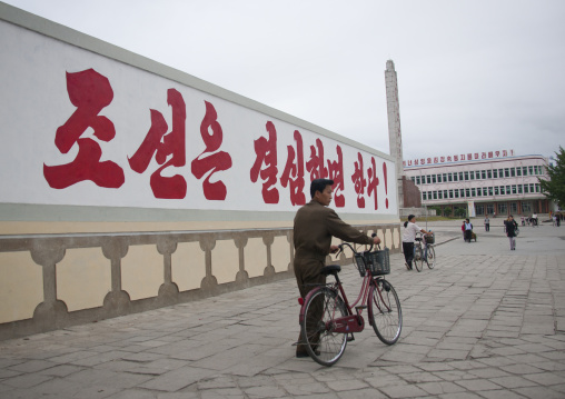 North Korean man passing in front of a propaganda billboard, North Hwanghae Province, Kaesong, North Korea