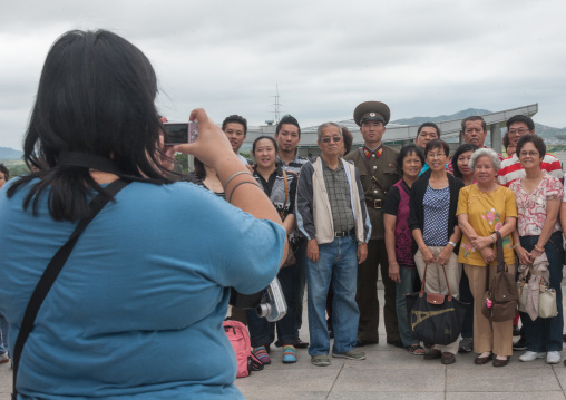 Tourists taking photos with a North Korean soldier on the Demilitarized Zone, North Hwanghae Province, Panmunjom, North Korea