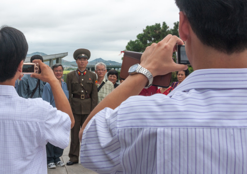 Tourists taking photos with a North Korean soldier on the Demilitarized Zone, North Hwanghae Province, Panmunjom, North Korea