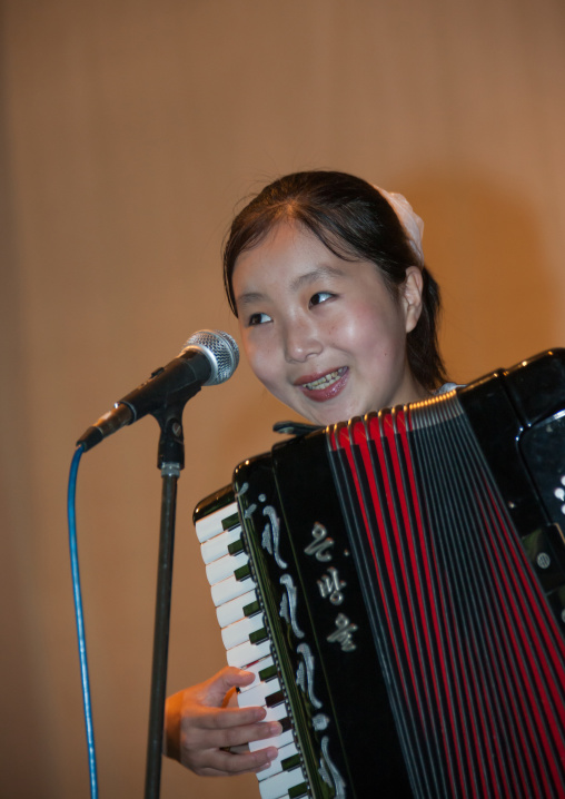 North Korean pioneer girl playing accordion, Pyongan Province, Pyongyang, North Korea