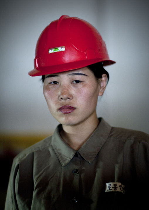 North Korean worker woman wearing a red helmet in a factory, South Pyongan Province, Nampo, North Korea