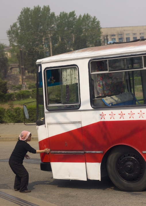 North Korean woman cleaning a public bus with red stars one star represents 50000 km of safe driving, Pyongan Province, Pyongyang, North Korea
